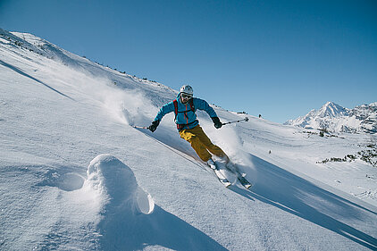 Skifahrer fährt den Berg hinunter