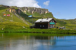 Bergsee am Großglockner mit einer Alm im Hintergrund