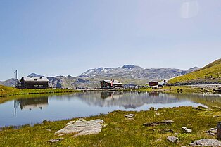 Kleiner Bergsee und zwei Almhütten als Raststätte entlang der Großglockner Höhenstraße