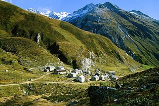 Von oben fotografiert- kleinen Almdorf umringt von grünen Bergen